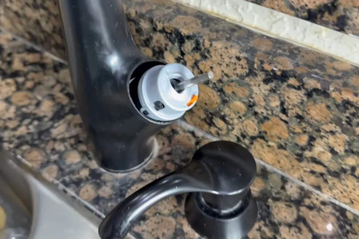 Faucet cartridge and new quarter-turn shutoff valves during a sink repair in Roswell, GA