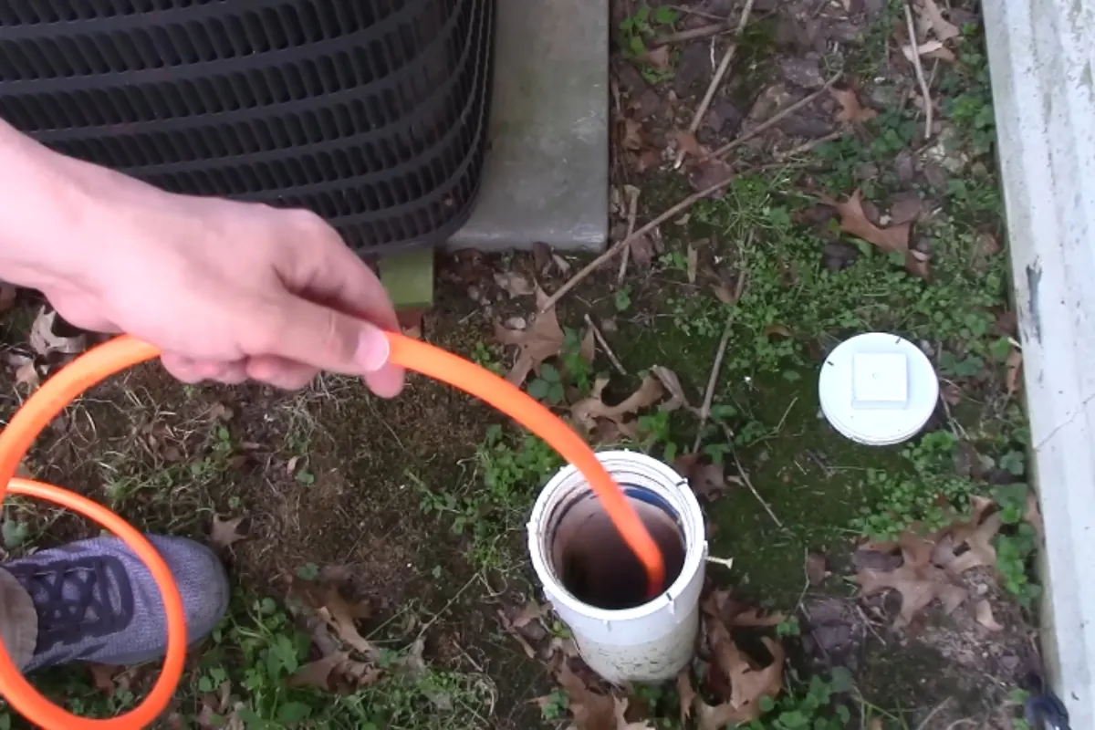 Hydro jetting hose feeding into an outdoor sewer cleanout at a Roswell, GA home