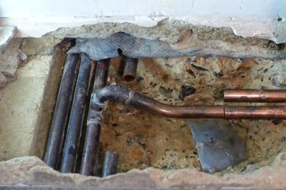 Slab leak exposed through a small opening in a concrete floor in Roswell, GA